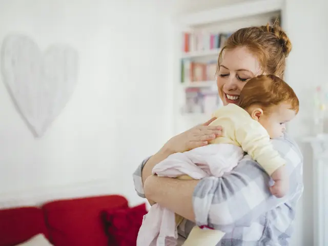 Mutter hält Baby im arm und kuschelt