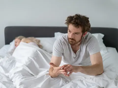 Mann und Frau liegen nachdenklich im Bett