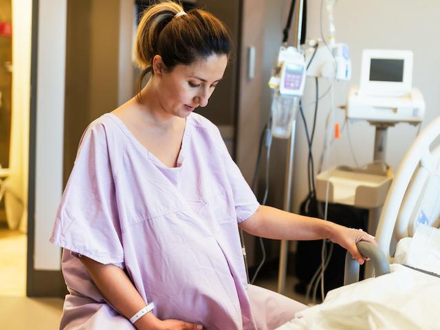 Schwangere Frau im Krankenhaus am Bett