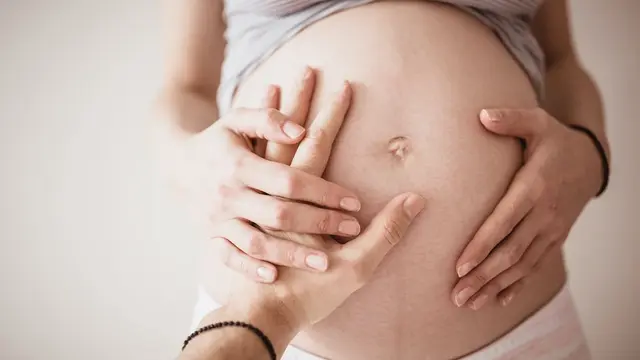 Frau und Mann fühlen Babybauch