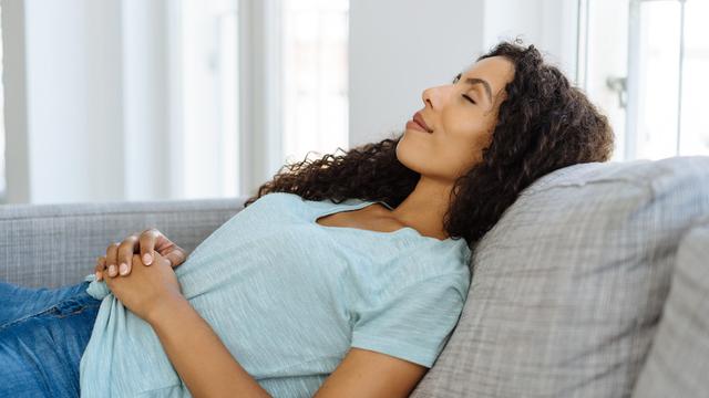 Schwangere Frau liegt entspannt