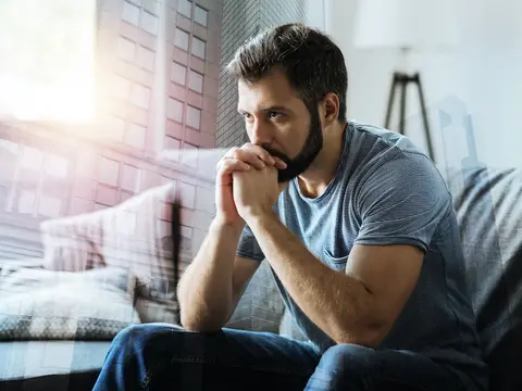 Mann sitzt bedrückt auf dem Sofa