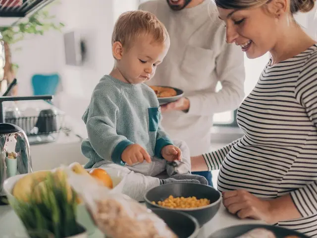 Familie mit schwangere Frau kocht