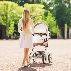 Frau mit Kinderwagen in der Natur