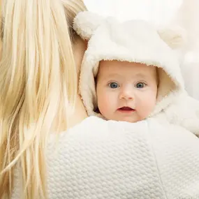 Baby auf dem Arm schaut in Kamera