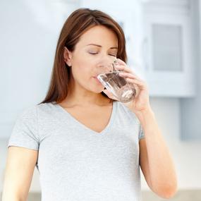 Schwangere Frau trinkt Wasser