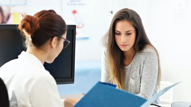 Frau sitzt beim Arzt zur Besprechung