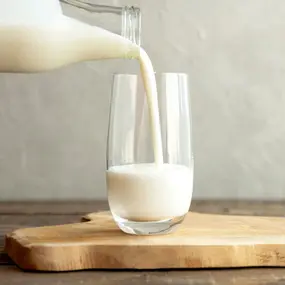 Milch wird in Glas eingeschenkt