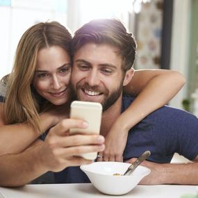 Mann und Frau schauen auf Smartphone