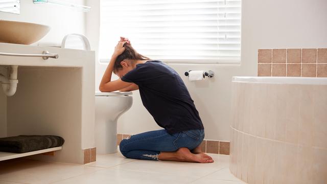 Schwangere Frau mit Schwangerschaftsbeschwerden im Badezimmer
