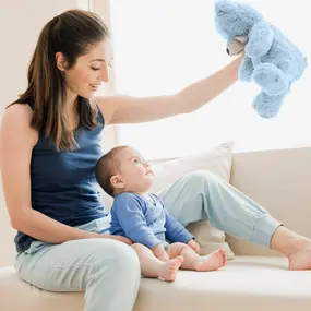 Mutter sitzt mit Baby auf dem Sofa