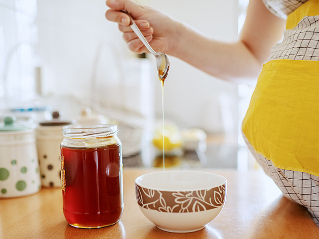 Schwangere süßt mit Honig