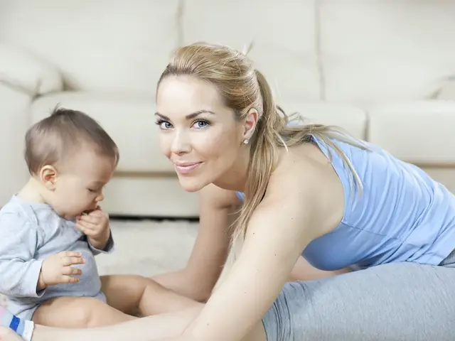 Mutter sitzt mit Baby auf dem Boden