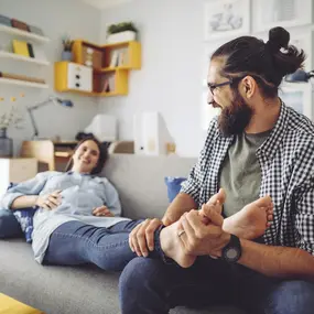 Schwangere Frau sitzt mit Mann auf dem Sofa