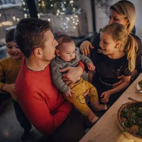 Baby mit Familie drumherum