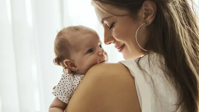 Frau hält Baby auf dem Arm