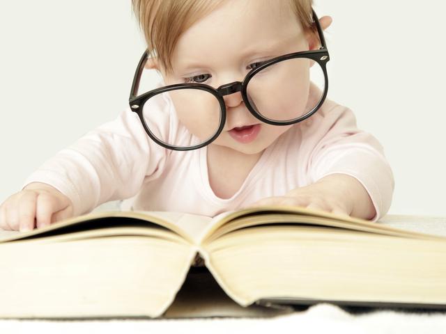 Baby mit Brille am lesen