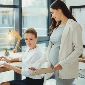 Schwangere Frau im Gespräch auf der Arbeit