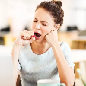Frau gähnt, wegen Folsäuremangel