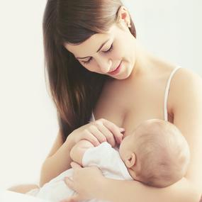 Frau stillt Baby im Arm