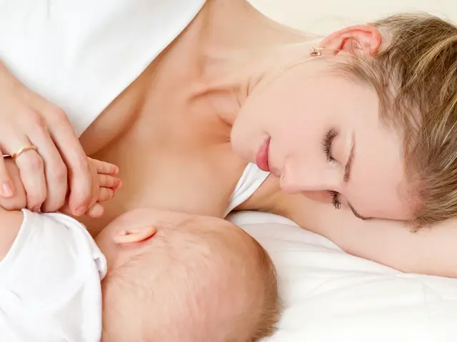 Mutter liegend stillt Baby mit Kopf zur Kamera