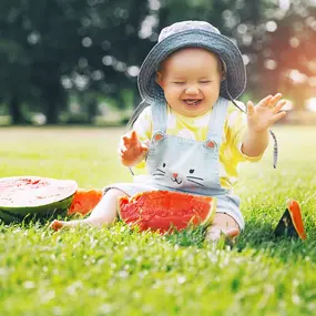 Baby sitzt auf dem Rasen