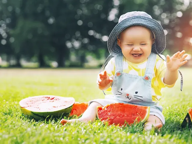 Baby sitzt auf dem Rasen