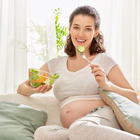 Schwangere Frau isst kleine Mahlzeit