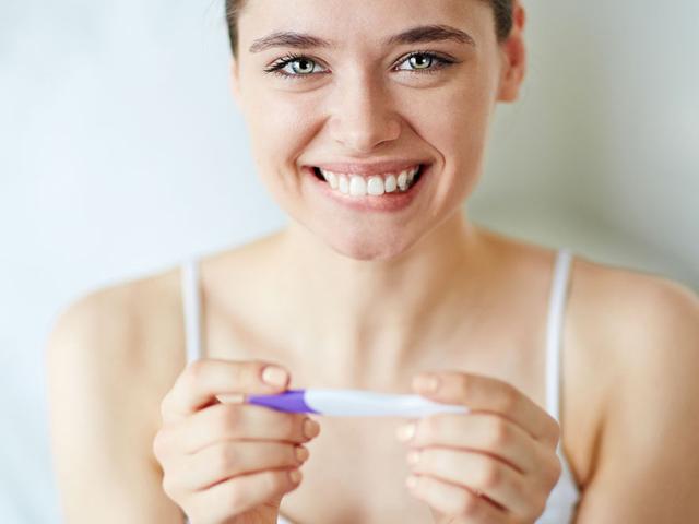 Frau glücklich mit Schwangerschaftstest