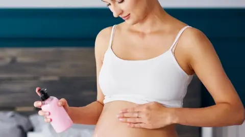 Frau pflegt Ihren Babybauch