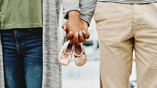 Paar hält Kinderschuhe in der Hand