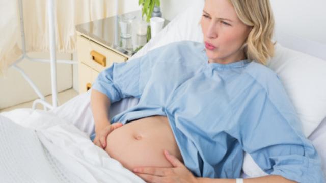 Schwangere Frau liegend mit Wehen