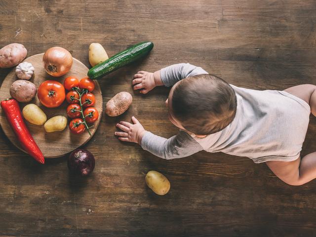 Baby krabbelt zur Gemüse