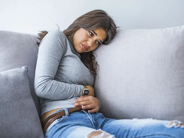 Frau sitzt mit Kinderwunsch auf dem Sofa