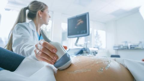 Schwangere Frau während Ultraschall bei Ärztin